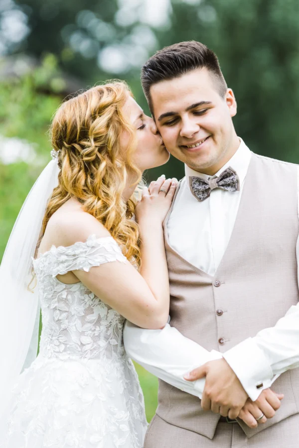 Ein warmer Wangenkuss der Braut für ihren Bräutigam