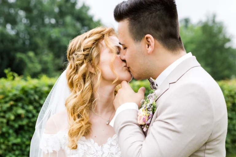 Der Bräutigam küsst seine Braut bei ihrer Hochzeit im Landhotel Voshövel – ein emotionaler Moment voller Liebe.